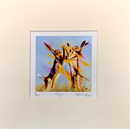 A matted art print featuring an expressive painting of two hares jumping in the air against a light blue background, with yellow, purple, and orange brushstrokes. The print is centered on a large cream-colored mat board with handwritten signature and edition markings at the bottom.