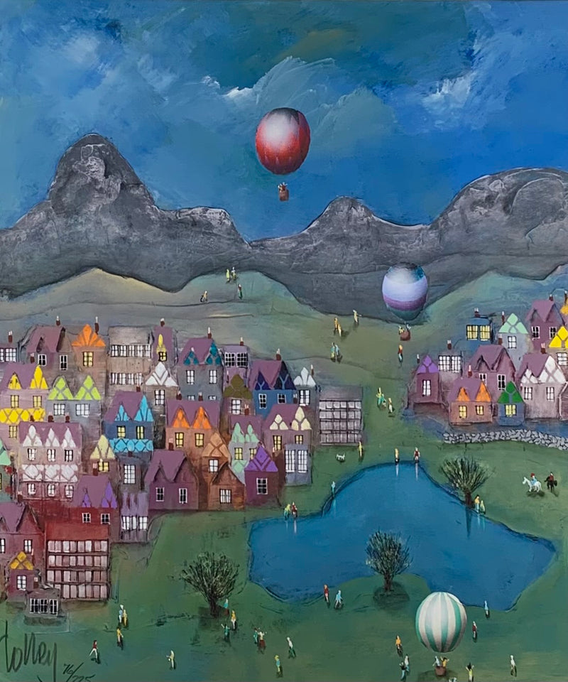 Colorful village scene with hot air balloons and mountains in the background