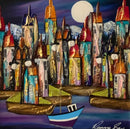 Where the Moon Guides Us by Rozanne Bell — blue boat in a moonlit harbour beneath tall, colourful houses with pointed red and orange rooftops, pale mountains and an indigo sky, presented in a glossy black frame with a white inner slip