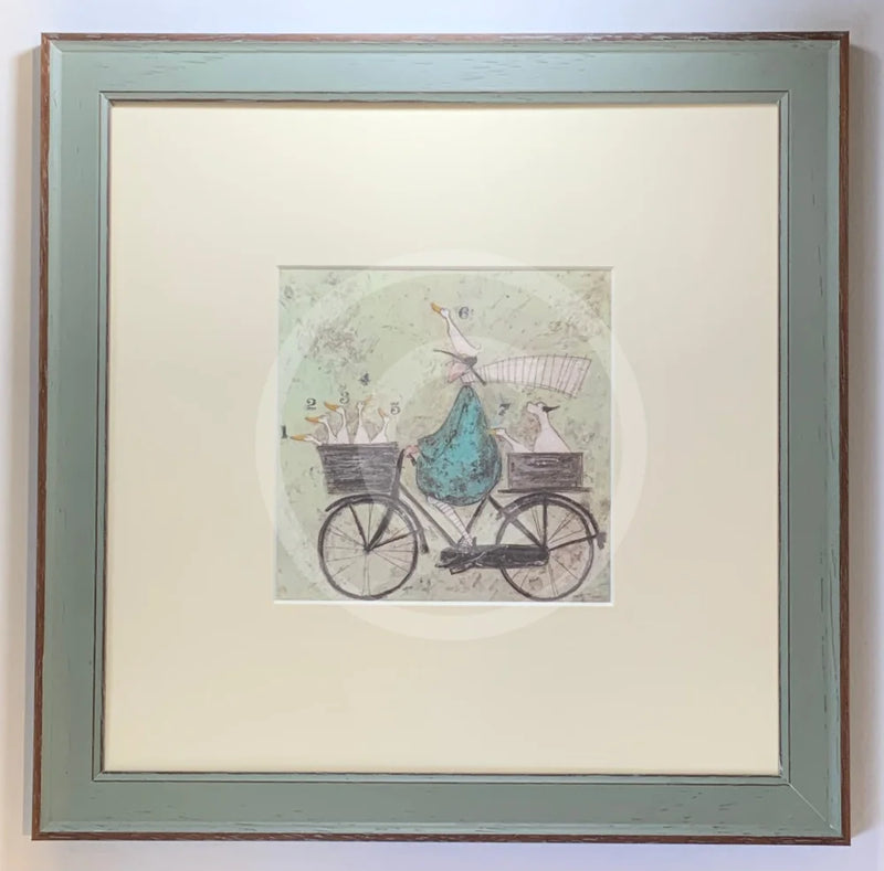 Meet the Mustards: All Aboard the Ducky Express by Sam Toft, mounted miniature print. A fun pictures of a man on a bicycle with two baskets carrying several white ducks and his black and white dog. Framed in Nordic Blue.