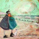 Meet the Mustards: Counting White Horses by Sam Toft, mounted miniature print. A couple on a beach with a black and white dog embracing, and looking up a the clouds. 