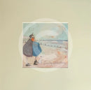 Meet the Mustards: Counting White Horses by Sam Toft, mounted miniature print. A couple on a beach with a black and white dog embracing, and looking up a the clouds. 