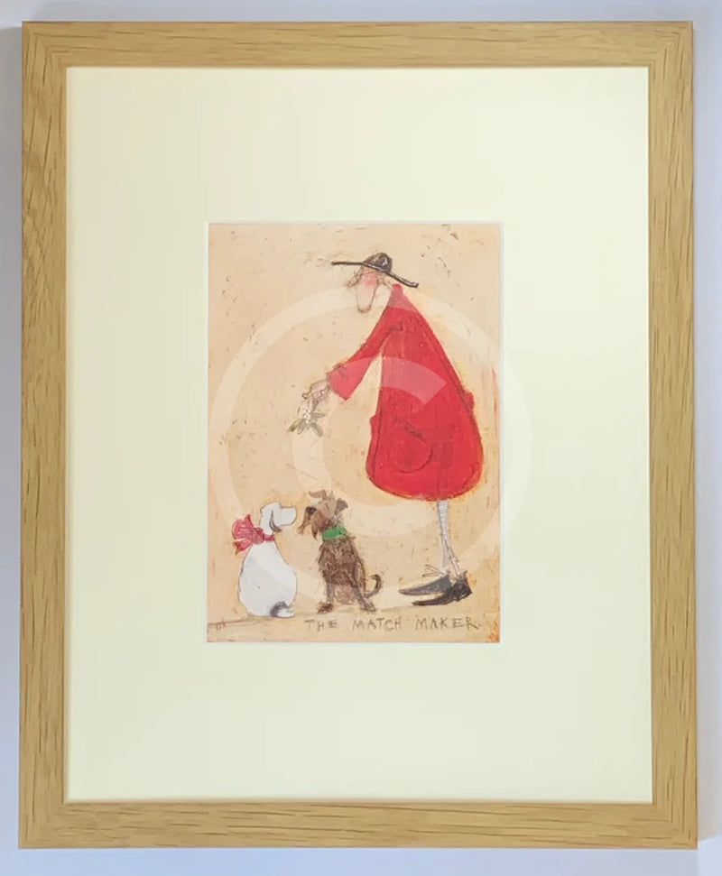 Meet the Mustards: The Match Maker by Sam Toft, mounted miniature print. A Christmas picture with a man in a red coat holding mistletoe over two dogs wearing a red bow and green collar. Framed in oak.