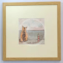 Meet the Mustards: Sea Cat by Sam Toft, mounted miniature print. A ginger cat sitting looking out to sea next to a miniature light house. Framed in oak.