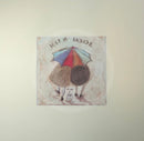 Meet the Mustards: Warm Inside by Sam Toft, mounted miniature print. A nostalgic picture of a couple, Mr Mustard and his wife Violet, viewed from the back walking under a brightly coloured umbrella with their black and white dog Doris following behind. 