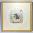 Meet the Mustards: Yay! by Sam Toft, mounted miniature print. A fun picture of a man, Mr Mustard holding a red balloon, rebelliously riding his scooter along the promenade, with his black and white dog Doris on board.  Framed in oak.