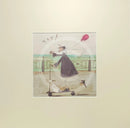 Meet the Mustards: Yay! by Sam Toft, mounted miniature print. A fun picture of a man, Mr Mustard holding a red balloon, rebelliously riding his scooter along the promenade, with his black and white dog Doris on board.  