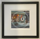 Framed artwork of a store front with a sheep and dog outside, titled 'Dali’s Clock Repairs'. Quirky sheep picture Dali’s clock repair shop