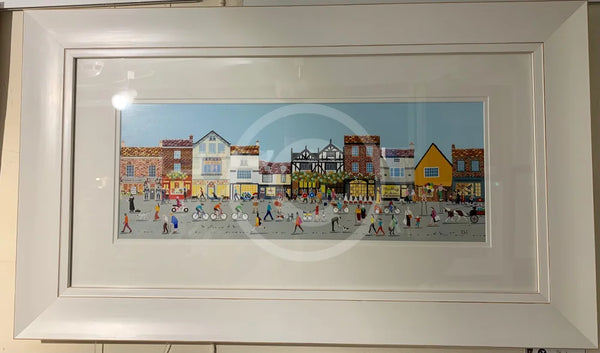 Framed artwork of a colourful York street scene with buildings and people.