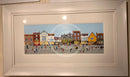Framed artwork of a colourful York street scene with buildings and people.