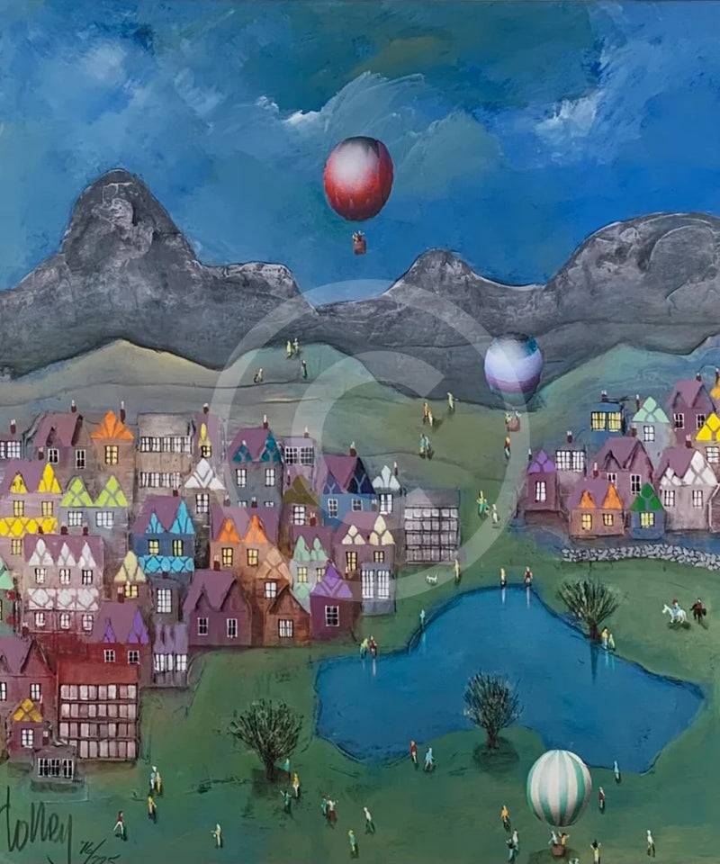 Colorful village scene with hot air balloons and mountains in the background