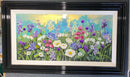 Framed artwork of a colorful floral scene with a black frame.