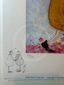 A close-up of a printed artwork page featuring a whimsical illustration. The right side shows part of a large mustard-yellow shape with a black boot-like form against a pale blue and pink textured background.
