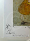 A close-up of a printed art piece showing part of a whimsical illustration with a yellow dress, black shoes, and a small hand-drawn figure below, with text reading 'A Big Old Squishy!' and 'by Sam Toft'.