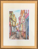 Framed illustration of a colourful Shambles in York street scene with a bicycle and a dog.