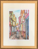 Framed illustration of a colourful Shambles in York street scene with a bicycle and a dog.