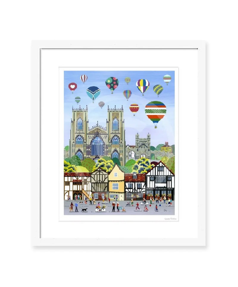 York Balloon Fiesta contemporary colourful art print by Linda Mellin. York Minster with hot air balloons, portrait shaped cityscape. White frame. 